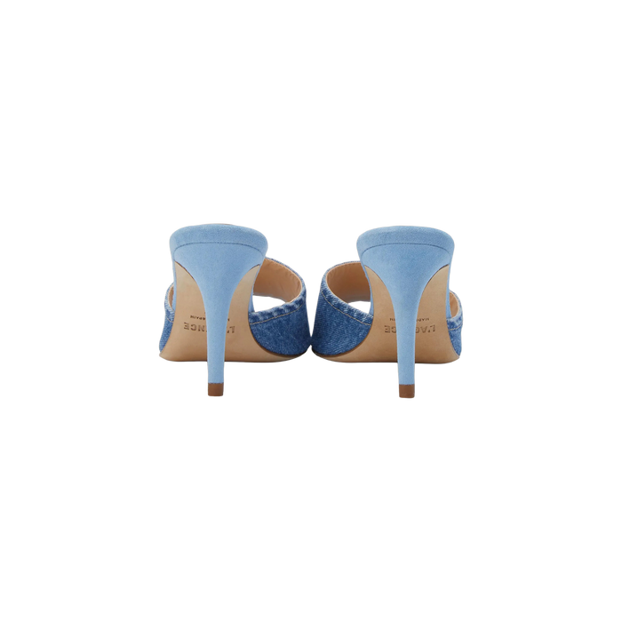 The Lolita Denim Open-Toe Mule is displayed from the back on a white background, showcasing its light blue denim upper, slim heels, and denim-textured sides.