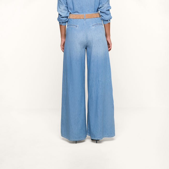 A person stands facing away, showcasing only the lower half of their body in the Lorenza Palazzo Jean against a plain white background.
