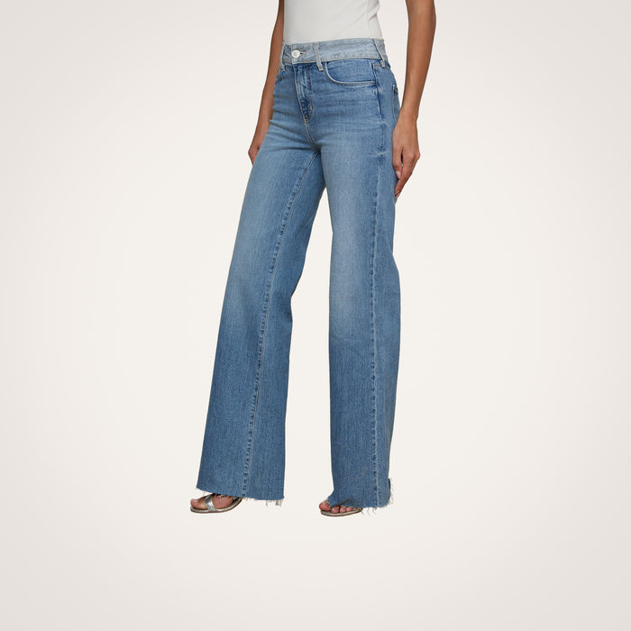 A person wearing the Louane Wide-Leg Flare Jean and a white top is standing against a plain white background.