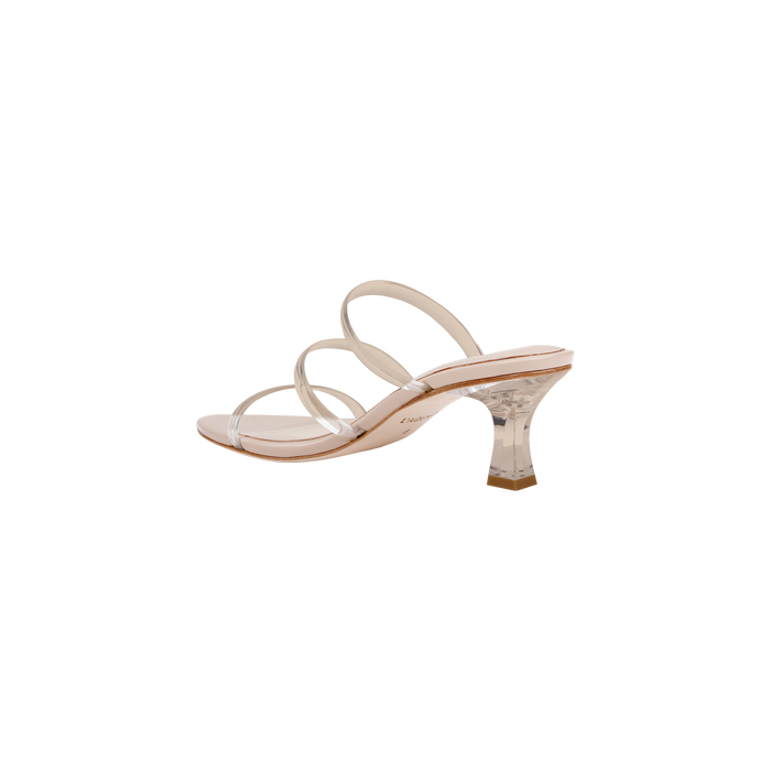 The Ludovica Kitten-Heel Sandal features three clear vinyl bands and a transparent, flared acrylic heel. Designed with a nude sole and a minimalist, modern silhouette inspired by the classic mule, this heeled sandal is photographed on a plain white background.