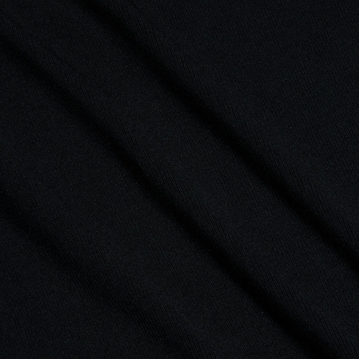 Close-up of the Shania Racerback Tank in black, showcasing ribbed knit fabric with subtle diagonal folds and a slightly visible woven texture.