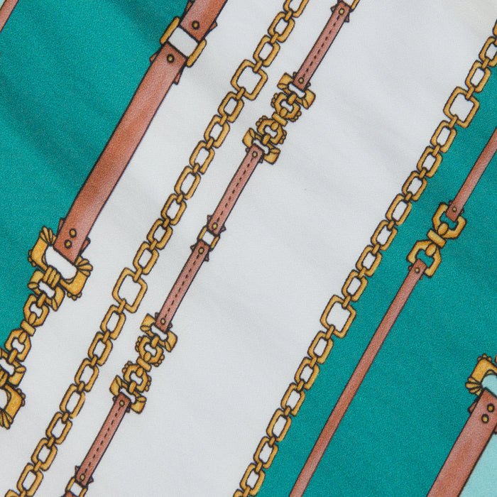 Introducing the Marceline Short Pareo, featuring a belt-stripe print with diagonal brown leather belts adorned with gold buckles and gold chains, set against an alternating green and white background—perfect as a stylish swimsuit cover-up.