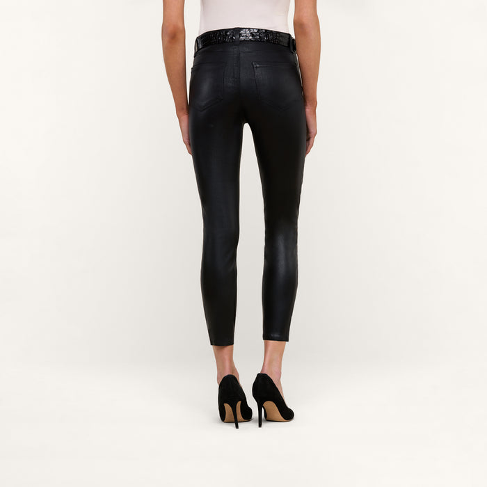 A person shown from the back against a plain white background is wearing the Margot Coated Cropped Skinny Jean in black, paired with a white top and black high heels.