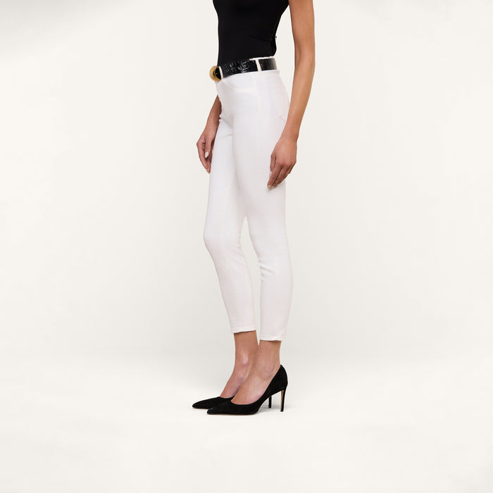 A woman in a black sleeveless top, black belt, black high heels, and the Margot Cropped Skinny Jean stands against a plain white background, shown from mid-shoulder to feet.
