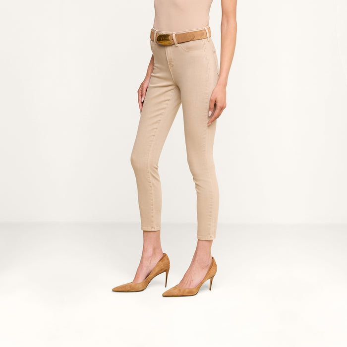 Model wearing tan high heels, Margot Cropped Skinny Jean in beige with a contoured waistband, a beige belt, and a beige sleeveless top. The photo is taken against a plain white background, showing the model from shoulder to feet.
