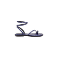 The Mariana Leather Sandal is a purple, flat leather sandal with a textured pattern, shown in a side profile view on a plain white background. It features a toe loop, single front strap, and an ankle strap with buckle closure.