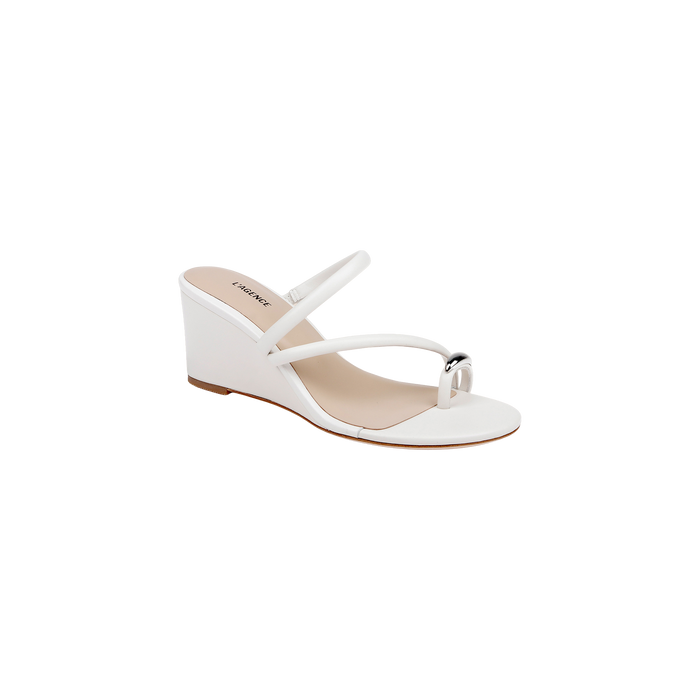 The Maritza Wedge Sandal features an open toe design with slim double straps and a small metallic accent on the front strap. Designed for comfort and stability, it offers a walkable medium-height wedge, a beige sole, and a memory foam insole. Displayed against a plain white background.