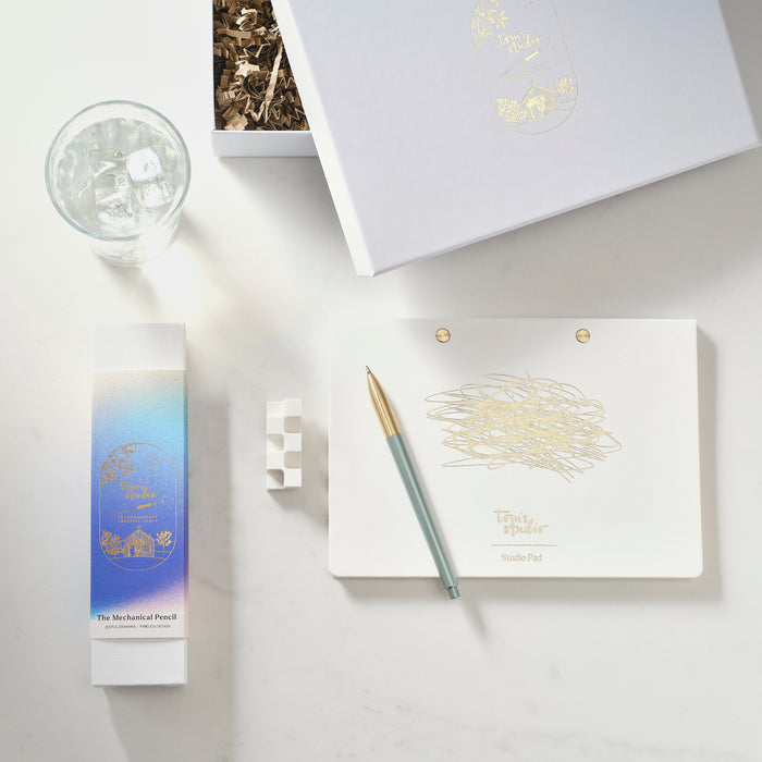 mechanical pencil gift set items including a mechanical pencil, notebook, and small box on a light surface.