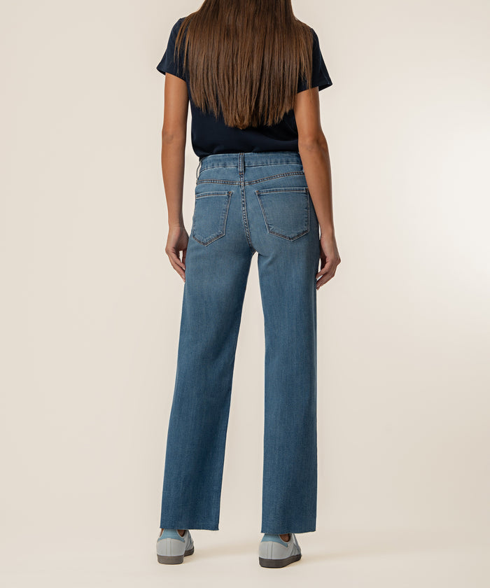 Light blue wide-leg jeans with high rise waistband shown from back view on model wearing navy shirt.