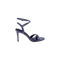 Introducing the Miranda Leather Sandal: a single high-heeled sandal crafted in textured dark purple leather, featuring an ankle-wrap strap with a buckle and two crossing straps over the toes—an elegant choice for pairing with evening gowns.