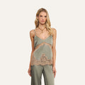 A woman with long blonde hair wears the Mitsu Satin Lace Camisole in light green, paired with matching pants featuring tan lace trim, while standing against a plain white background. The lingerie-inspired top adds an elegant touch to her outfit.