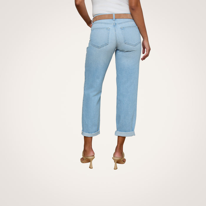 A person wearing the Nevia Slouchy Straight-Leg Jean in a light wash, cuffed at the hem, paired with a white top and beige heeled sandals, is shown from the back against a plain white background.