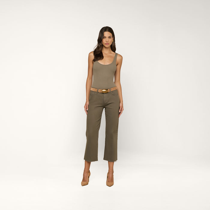 A woman stands facing forward, wearing the Nica Scoopneck Bodysuit in a sculpted fit, olive cropped pants with a tan belt, and tan high heels against a plain light background.