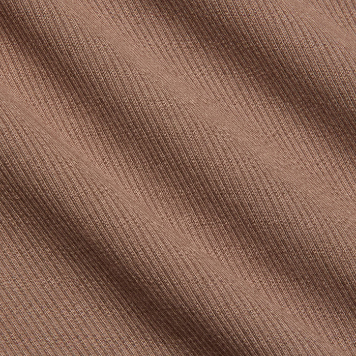 Close-up of the Nica Scoopneck Bodysuit in light brown stretch rib fabric, featuring diagonal textured lines that create a subtle pattern and soft shadows across the surface.