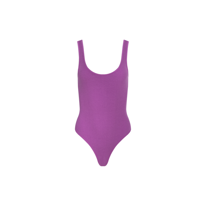 Introducing the Nica Scoopneck Bodysuit—a sleeveless, sculpted-fit bodysuit in purple, featuring a scoop neckline and high-cut leg. Made from high-recovery stretch rib fabric, it’s shown against a plain white background.