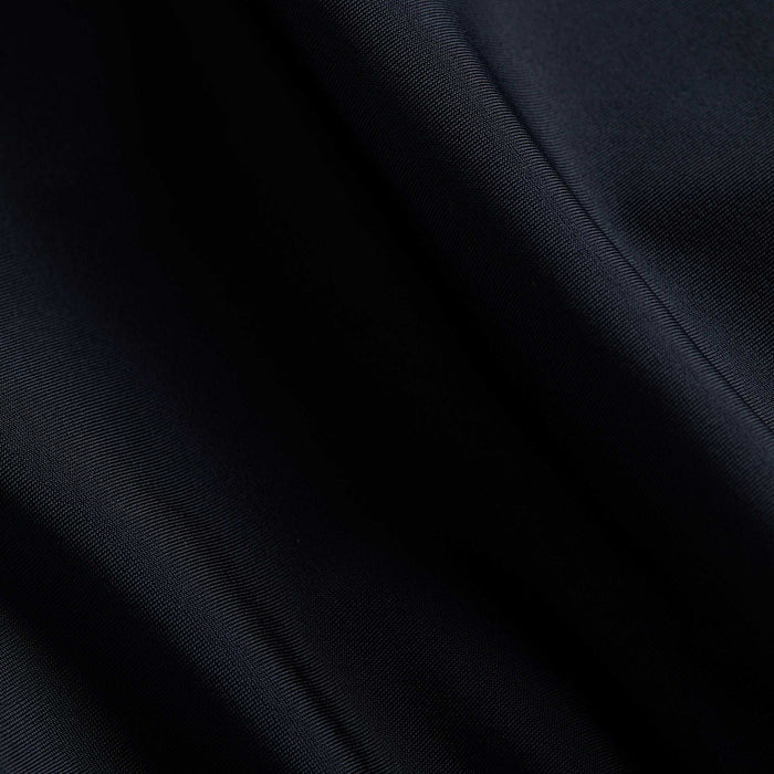 Close-up of smooth, dark navy blue fabric with soft folds and gentle light reflections highlighting the texture, reminiscent of the versatile Nicole Bikini Bottom.