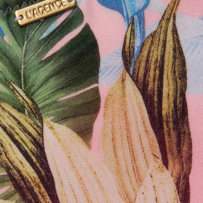 Close-up of the Nicole Bikini Bottom, showcasing a tropical palm leaf print in green, yellow, and brown on a pink background, with a small metal LAGENCE label.