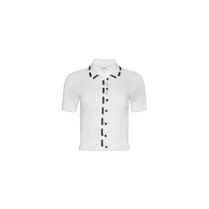 Ninette Knit Top: A white short-sleeve pointelle knit cardigan featuring a collar, front buttons, and black grosgrain ribbon trim along the button line and collar edges, displayed on a plain white background.