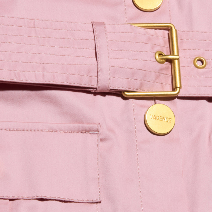 Close-up of the Noam Poplin Shirt Dress in light pink cotton poplin, featuring a pocket, stitched waist belt, and two round gold buttons—one engraved with “LAGENCE.”.