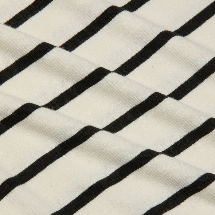 Close-up of the Nura Racerback Midi Dress fabric, featuring black horizontal stripes on a white background that create a wavy, textured pattern.