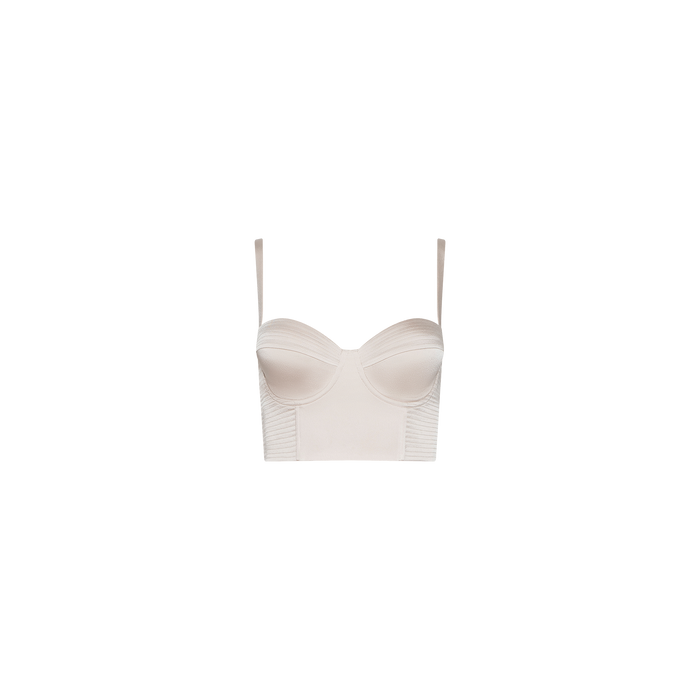 The Nysa Bustier Top is a light beige, bustier-style crop top featuring adjustable straps, structured cups reminiscent of a satin underwire bra, and ribbed detailing along the sides. It is displayed on a plain white background.