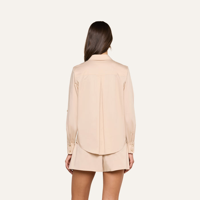 A woman with long brown hair, shown from the back, wears the Pearson Poplin Shirt in light beige along with matching shorts against a plain white background.