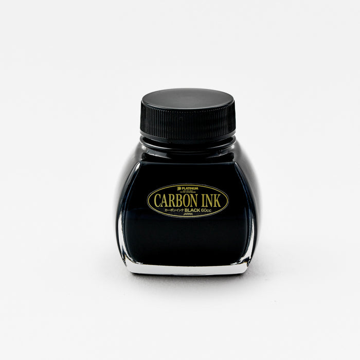 A front-facing image of the Platinum Carbon Ink bottle. The label is fully visible, featuring the "Carbon Ink" logo in gold lettering against a black background. The glass bottle has a distinctive shape, and the deep black ink inside is prominently displayed.