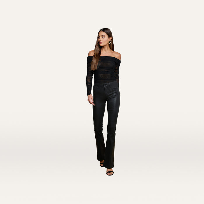 A woman models the Poppie Off-The-Shoulder Bodysuit in black, paired with fitted black pants and black heels, standing against a plain white background.