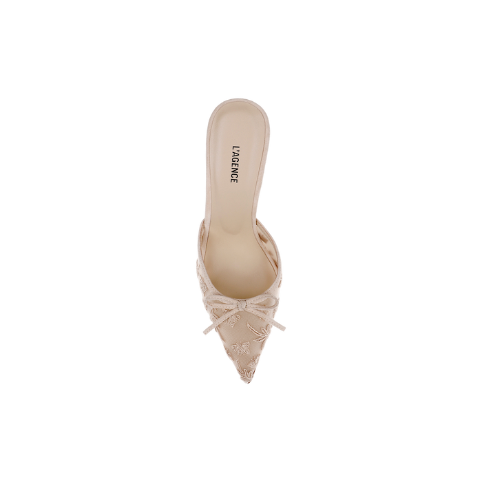 The Prasad Mesh Mule is a beige, pointed-toe mule adorned with a decorative bow on the front, featuring butterfly embroidery and delicate embroidered details. The insole is labeled LAGENCE, and the shoe is displayed from a top-down view against a white background.