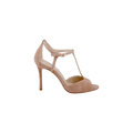 Radha Suede Sandal in beige cappuccino features a high heel, T-strap design, brogue detailing, ankle buckle closure, open toe, and closed heel, shown against a plain white background.