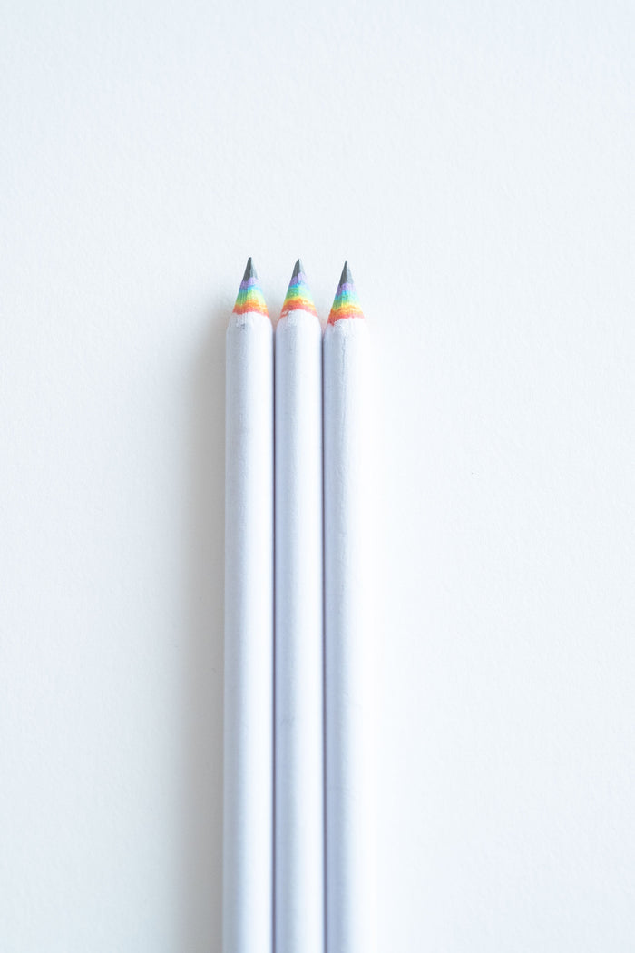 3 Rainbow pencils on a white desk