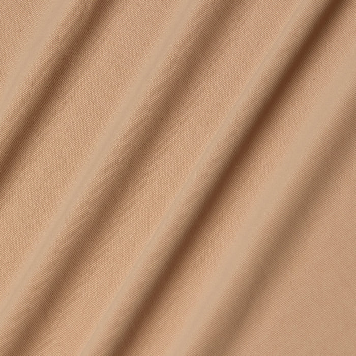 Light brown stretch jersey fabric forms the Raye Slip Lining Dress, its softly draped folds lending gentle shadows and textured dimension across the surface.