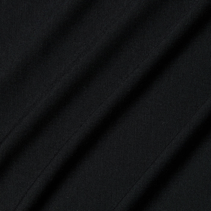 Close-up of the Remy Tee in black micro modal jersey fabric with diagonal folds and visible texture, highlighting its fine knit pattern and subtle shadows for a relaxed fit.