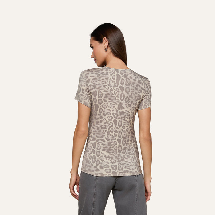 A woman stands with her back to the camera, wearing the bestselling Ressi Fitted Tee in gray leopard print and gray pants, against a plain light background.