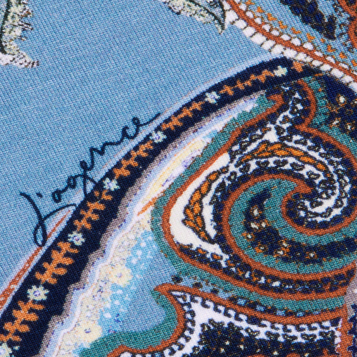 Close-up of the Ressi Fitted Tee in midnight blue paisley, featuring an intricate orange, green, and white pattern with the signature Jaeger written in dark ink on the left side.
