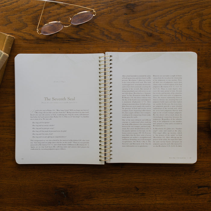 Revelation Spiral Study opened to page 106, the Seventh Seal, on a wooden table next to a pair of glasses