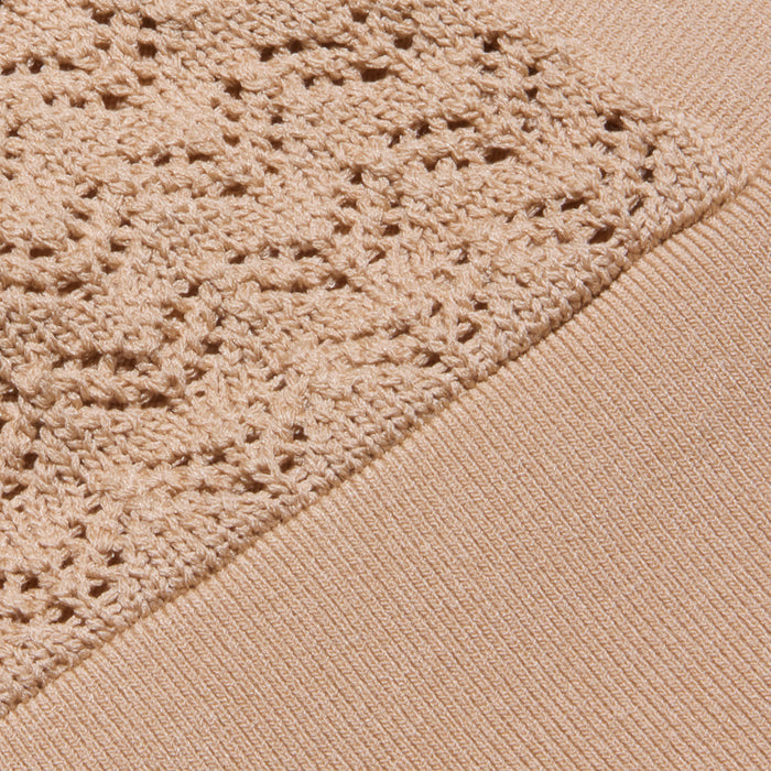 The Reverie Pointelle Knit Bralette showcases a beige fabric with a textured, lacy pointelle knit pattern alongside a smoother, ribbed knit section. The image highlights the contrast between these two knitting styles.