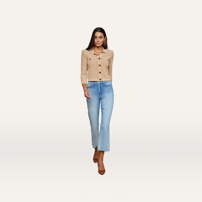 A woman wearing the Risa Collared Cardigan in beige, light blue cropped jeans, and brown heels walks forward against a plain white background.