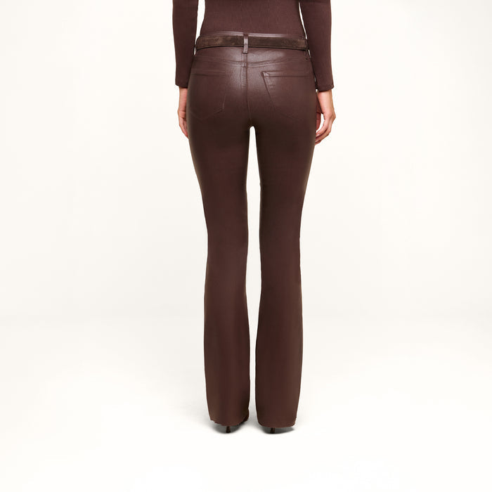 A person stands with their back to the camera against a plain white background, wearing the Ruth Coated Straight-Leg Jean in brown paired with a matching long-sleeve top.