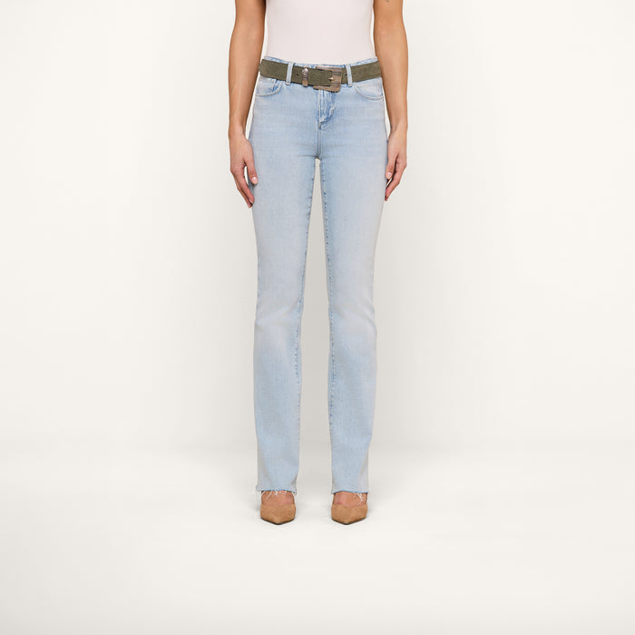 A person wearing the Ruth Straight-Leg Jean in classic stretch denim, paired with a brown belt, a white top, and brown shoes stands facing forward against a plain white background.