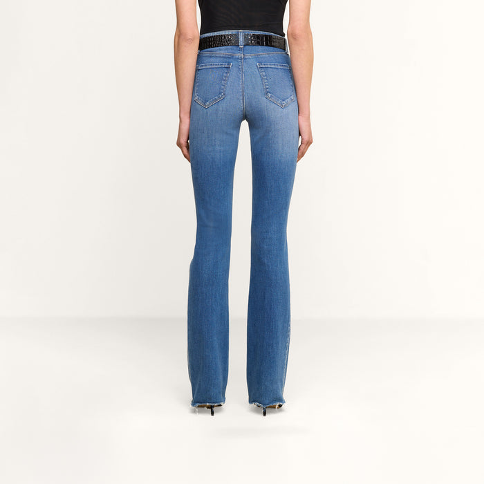 A person wearing Ruth Straight-Leg Jean in premium stretch denim blue and a black top, shown from the back, standing against a plain white background.