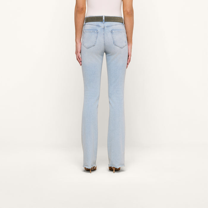 A person is shown from the back, modeling the Ruth Straight-Leg Jean in light blue, featuring back pockets and a contrasting waistband, styled with heeled shoes against a plain white background.