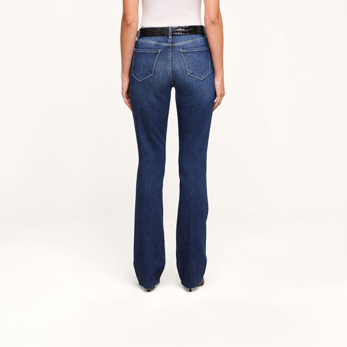 A person wearing Ruth Straight-Leg Jean in an indigo wash and a white top, shown from the back, standing against a plain white background.