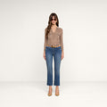 A woman wearing a brown long-sleeve top, tan belt, tan heels, sunglasses, and the Sada Cropped Slim-Leg Jean stands against a plain white background.