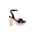 The Sandrine Platform Sandal is a navy blue suede high-heeled sandal with a platform sole, ankle strap and buckle, and features a chunky raffia-wrapped beige wedge heel, displayed against a plain white background.