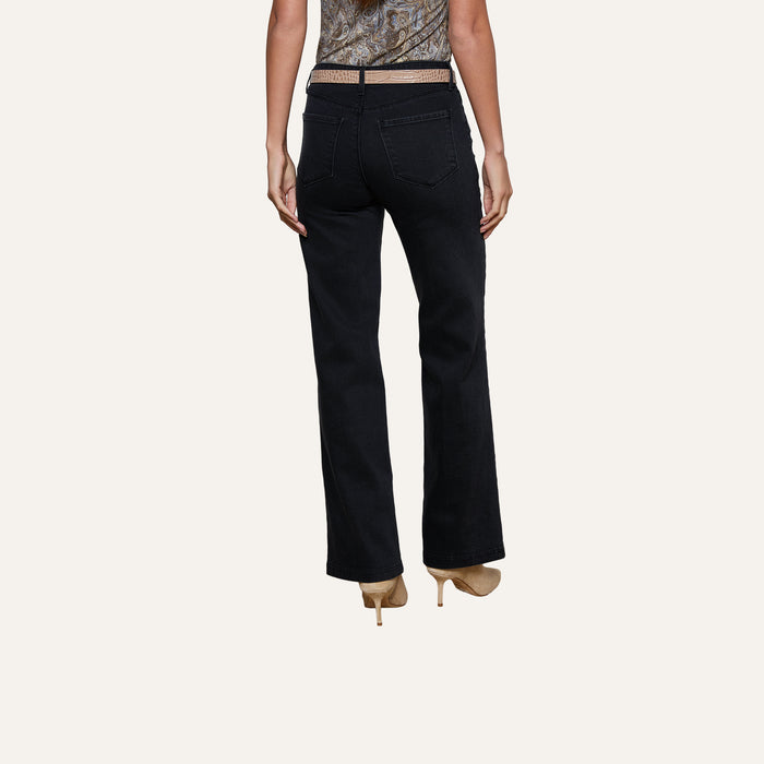 A person is shown from the back, standing against a plain light background, wearing the Scottie Wide-Leg Jean in black with a contoured waistband and beige high heels.