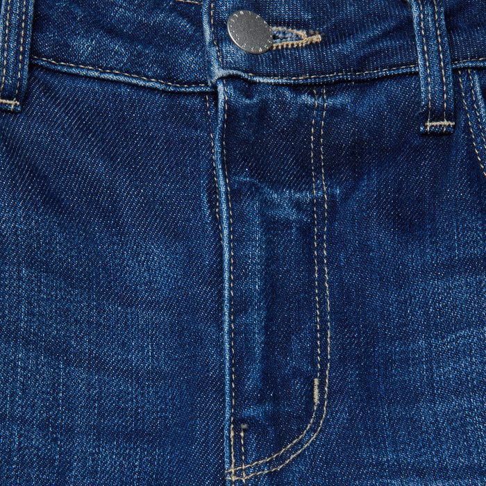 Close-up of the front of the Scottie Wide-Leg Jean in blue stretch denim, highlighting the contoured waistband, button, belt loops, zipper area, and part of the front pocket with visible stitching.