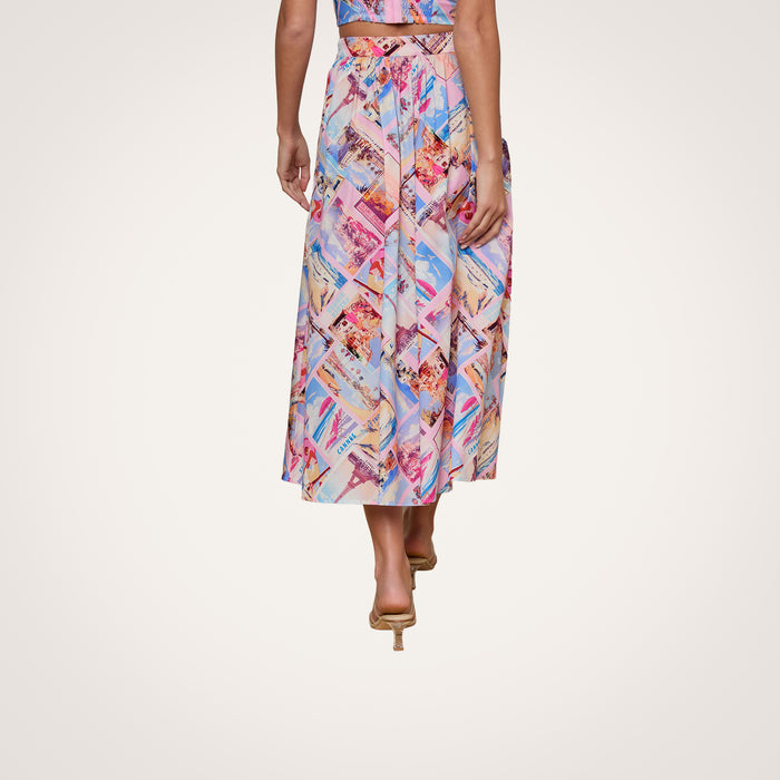 A person wearing the Seina Poplin Midi Skirt with a colorful, geometric pattern and heeled sandals stands with their back to the camera against a plain white background.