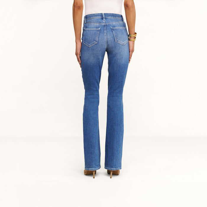 A person wearing the Selma Bootcut Jean and brown heels is standing with their back to the camera against a plain white background.