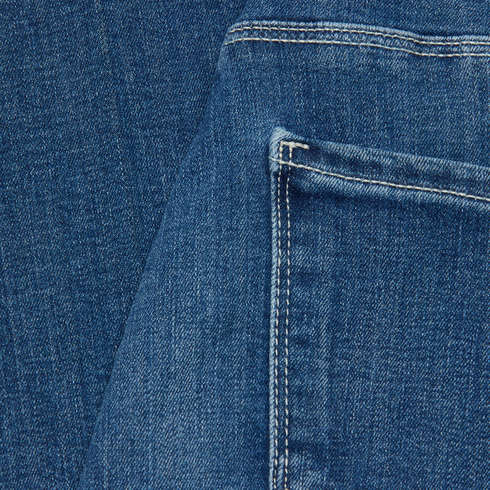 Close-up of the Selma Bootcut Jean in a dark wash blue denim, highlighting the back pocket with visible stitching. The texture of the material and seam details are clearly showcased.